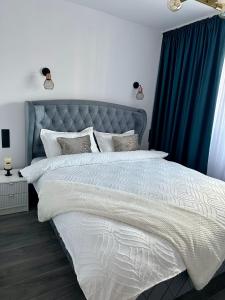 比斯特里察Evelyn Apartment的一间卧室配有一张带蓝色窗帘的大床