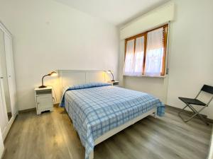 圣温琴佐Appartamento Elisa的卧室配有床、椅子和窗户。