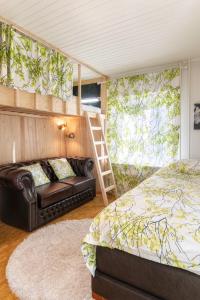 赫尔辛基Mäkkylän Helmi的一间卧室配有一张床、一张沙发和梯子