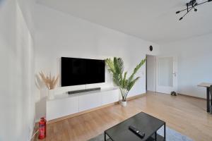 埃森Goodliving Apartments mit Netflix Büro und Parkplatz的白色的客厅设有白色墙壁上的平面电视。
