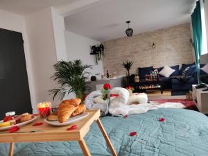 米卢斯Romantic Cocon Home in Mulhouse的一间客厅,床上有天鹅和面包