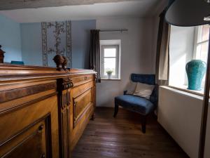 阿本贝格阿本贝格酒店的配有木制梳妆台和蓝色椅子的房间