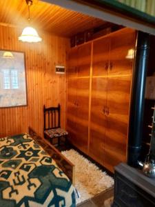 达尔德赫Vila Ceku的一间卧室设有一张床和木墙
