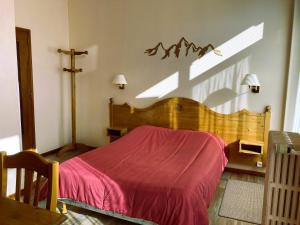 圣皮耶尔德沙尔特勒斯Hotel Victoria的一间卧室配有一张带红色毯子的木床
