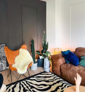 柏林Cozy&Modern 01bedroom in Mitte - Pet Friendly & Parking的带沙发、椅子和仙人掌的客厅