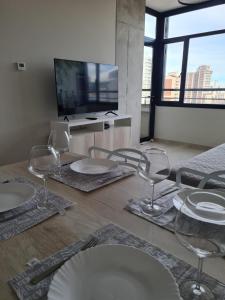 内乌肯Luxury Bim 7的一间带椅子和盘子及电视的用餐室