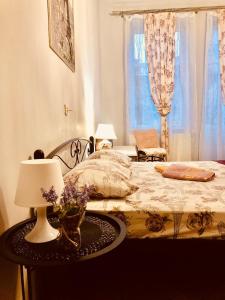利沃夫Vintage Apartment 2 rooms with Balcony的一间卧室配有一张床和一张带台灯的桌子