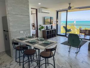 坎昆2BR Oceanfront Luxury Apartment in the Hotel Zone的一间配备有桌椅的海景用餐室