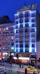 伊斯坦布尔伊斯坦布尔CVK塔克西姆酒店的一座高大的白色建筑,上面有蓝色的灯光