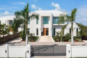 Long Bay HillsPrivate Pool Villa, Long Bay Beach with VIP Extras的一座棕榈树掩映的白色房子