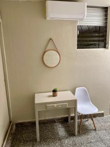 圣萨尔瓦多Lindo espacio, cómodo y céntrico的一张桌子和一把椅子,旁边是一面墙,一面镜子