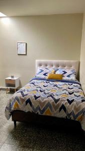 圣萨尔瓦多Lindo espacio, cómodo y céntrico的一间卧室配有一张带蓝色和白色棉被的床