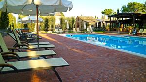 萨尔泰阿诺拉索瓦娜农庄酒店的毗邻带长椅和遮阳伞的游泳池