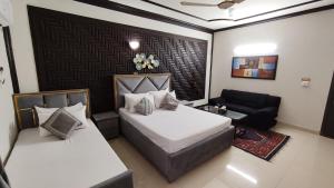 伊斯兰堡Aleph Islamabad Guest House的酒店客房,设有两张床和一张沙发
