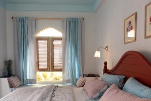 斋浦尔Rajan House的一间卧室设有一张床和一个窗口