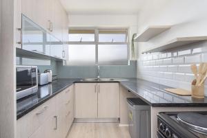 布鲁堡史特兰Blouberg Heights 207的厨房配有水槽和微波炉