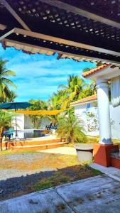 SipacateCasa Guadalupe的享有带遮阳伞和棕榈树的房子的景色