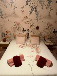 PrémilhatLe moulin de la Vernoelle的一间卧室配有一张带花卉壁纸的床