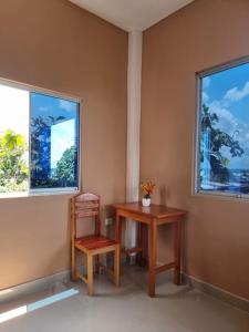 伊基托斯Casa Alojamiento Picuro Lodgind的一个带两扇窗户的房间,一张桌子和一把椅子