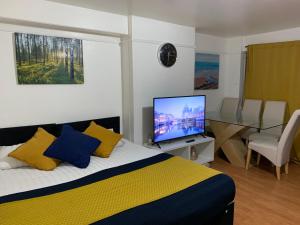 伦敦London Stratford 4 Bedrooms Apartment的一间卧室配有一张床和一台平面电视