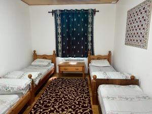 Yukary-UkhumHayat Guesthouse Nuratau Mountains的带三张床和窗户的客房