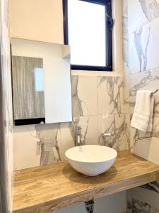 Chilpancingo Capital Suites的木制柜台上带白色碗水槽的浴室