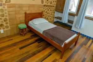 格拉瓦塔尔绿色生活环保旅馆的一间带床和凳子的小卧室