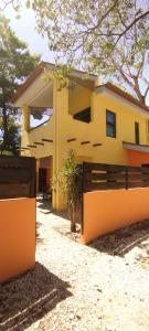 普拉亚弗拉明戈Hotel Tabasco的前面有栅栏的黄色房子