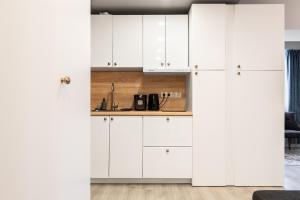 克卢日-纳波卡Romantic Jacuzzi Studio的厨房配有白色橱柜和柜台。