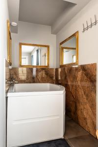 克卢日-纳波卡Romantic Jacuzzi Studio的浴室设有白色浴缸和两面镜子