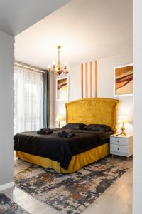 克卢日-纳波卡Romantic Jacuzzi Studio的一间卧室配有一张带黄色床头板的大床