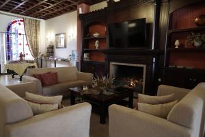 埃尔罗西奥Hospedarte Palacete Real的客厅设有壁炉和电视。