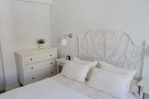 格拉纳达La morada del viajero的卧室配有白色的床铺和白色的枕头
