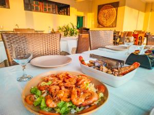 阿奎拉兹Planet Dunas Residence的一张桌子,上面放着一盘虾和沙拉