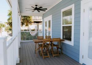 杰克逊维尔海滩Luxurious 4 Bedroom Home In Jacsonville Beach的门廊上设有木桌和椅子