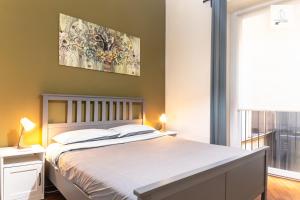 卡塔尼亚Gli Appartamenti al Duomo的卧室配有一张床,墙上挂有绘画作品