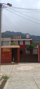 奇瓦伊Hospedaje Vacacional - Colca的一座红色的建筑,设有大门和栅栏