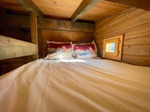 格施塔德Gstaad Chalet的小木屋内的一张大床,配有一张床铺