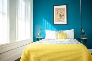 丹佛第11大道旅舍的蓝色卧室,配有一张黄色毯子床
