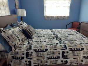 圣徒皮特海滩Beautiful St Pete Beach, FL 2nd Floor 2BR Unit的蓝色卧室配有带被子和枕头的床