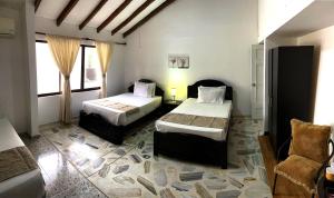 卡利圣洛朗酒店的一间卧室配有两张床和椅子