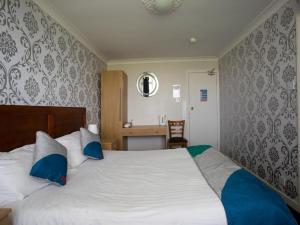 泰恩河畔纽卡斯尔Knowesgate Hotel B&B的一间卧室配有一张带蓝色枕头的大床