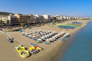 罗希姆诺Steris Elegant Beach Hotel & Apartments的享有海滩的空中景致,配有椅子和遮阳伞