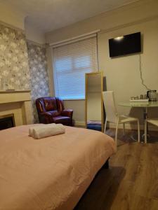 利物浦ArklesFCLiverpool的卧室配有一张床和一张桌子及椅子
