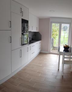 奥伦塞CASA MIRANDA的厨房配有白色橱柜、桌子和窗户。