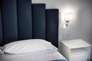 波西塔诺YourHome - H2O Marina Apt Sea View的一间卧室配有蓝色床头板和白色的床