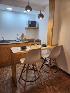 科尔多瓦Hermoso Apartamento en Edificio Saint Michel的厨房配有木桌和两把椅子