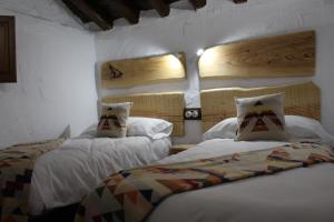 Cortijo Wenceslao II的一间卧室设有两张床和两个窗户。