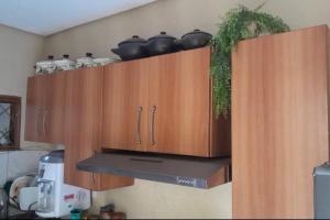 阿拉瓜伊纳Refúgio Aconchegante e Espaçoso的厨房配有带锅碗瓢盆的木橱柜