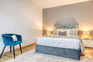 FaialCasa dos Anjos, a Home in Madeira的一间卧室配有一张床和一张蓝色椅子